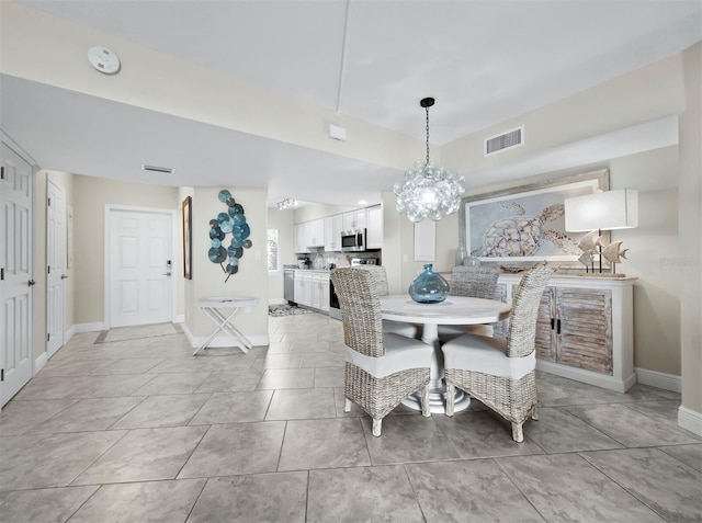 dining area with light tile patterned flooring and a chandelier