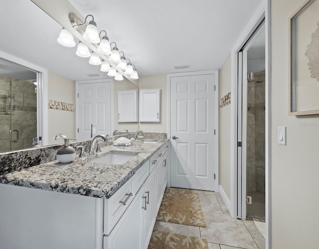 bathroom featuring a shower with door, tile patterned floors, and vanity