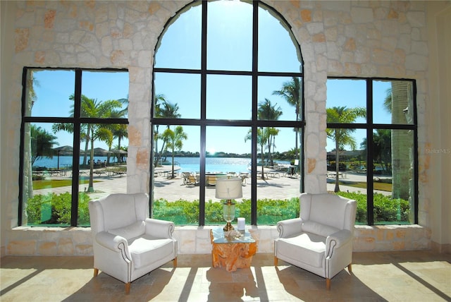 sunroom featuring plenty of natural light and a water view