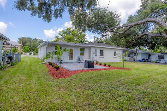 rear view of house featuring a lawn, a patio, and central air condition unit