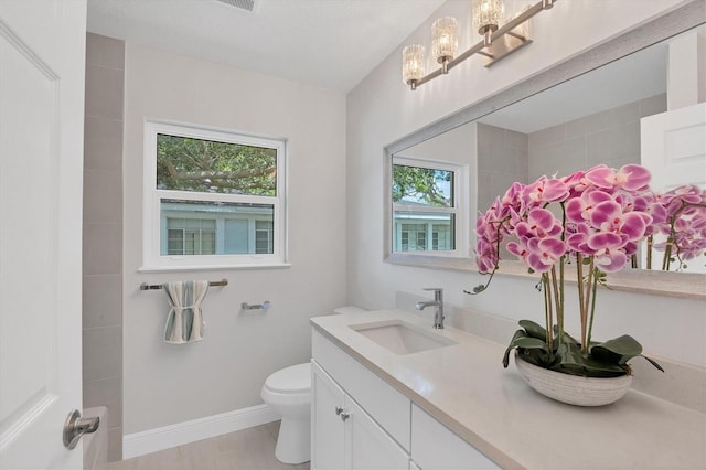 bathroom with tile patterned flooring, vanity, and toilet