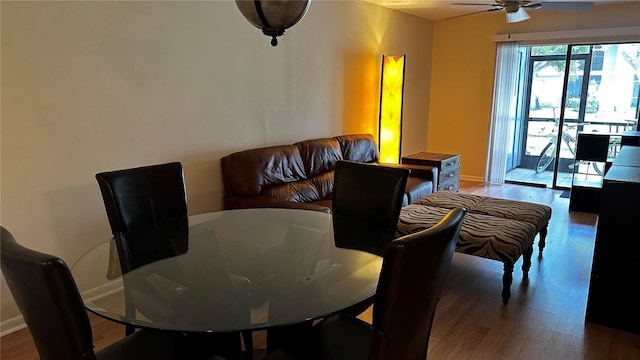 dining space featuring baseboards, a ceiling fan, and wood finished floors