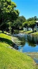 view of community featuring a lawn and a water view