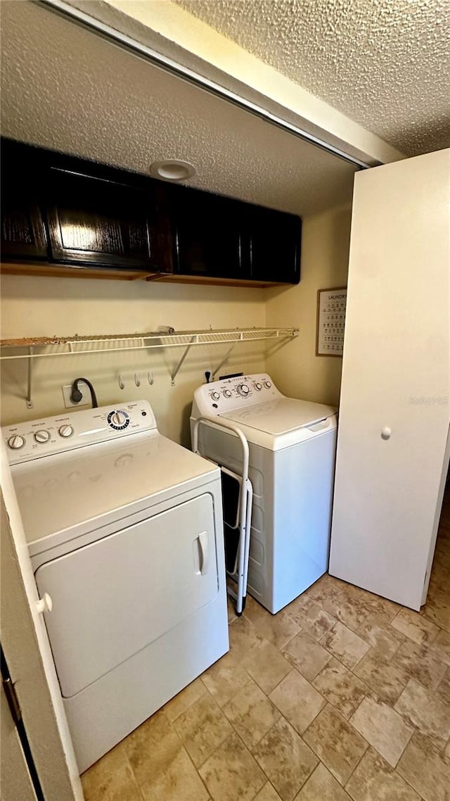 laundry area featuring cabinets, independent washer and dryer, and a textured ceiling