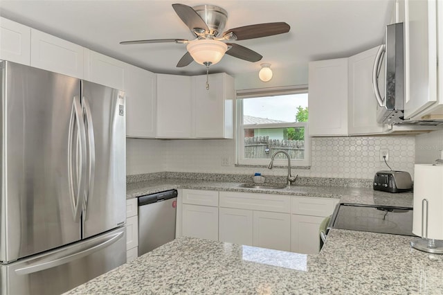 2900 Siesta Dr, Venice, FL 34293 - kitchen with decorative backsplash, white cabinetry, stainless steel appliances, and a sink