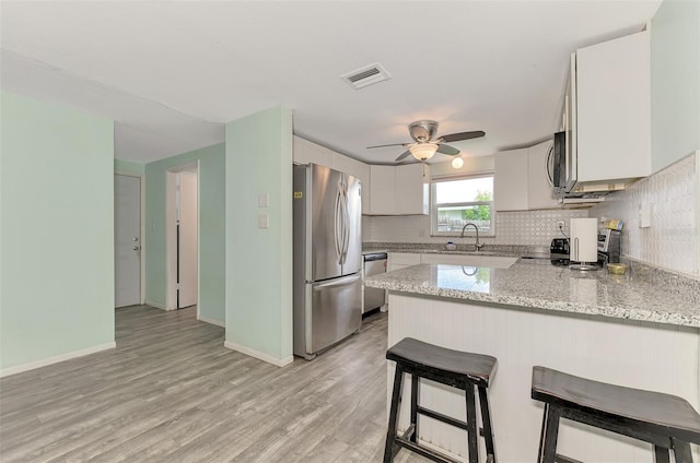 2900 Siesta Dr, Venice, FL 34293 - kitchen featuring stainless steel appliances, visible vents, decorative backsplash, a sink, and a peninsula