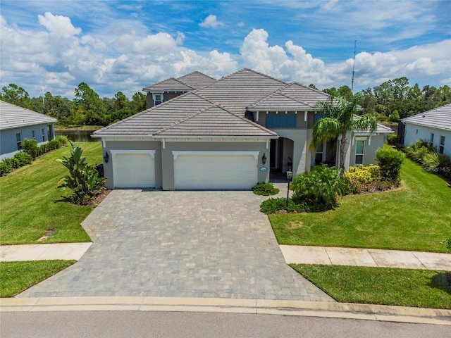 view of front of home with a garage, a front yard, decorative driveway, and a tiled roof