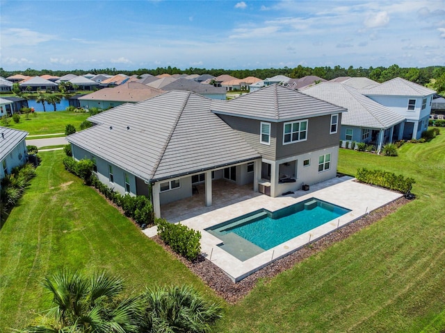 back of property with a lawn, a patio area, and a residential view