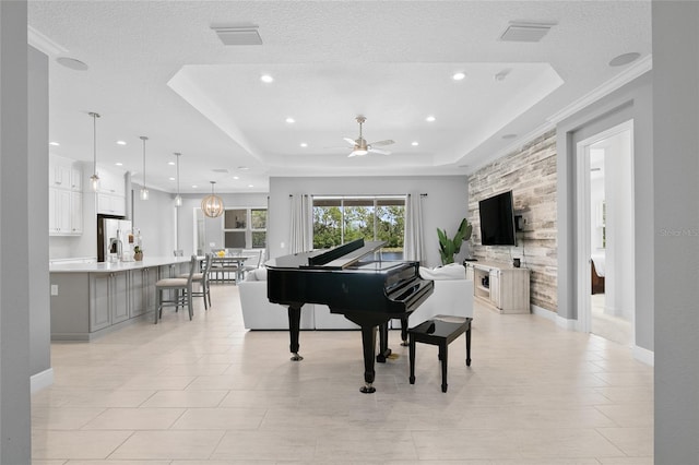 interior space featuring baseboards, visible vents, a raised ceiling, and a textured ceiling