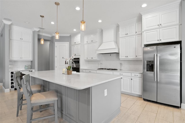 kitchen featuring light countertops, appliances with stainless steel finishes, custom exhaust hood, and white cabinets