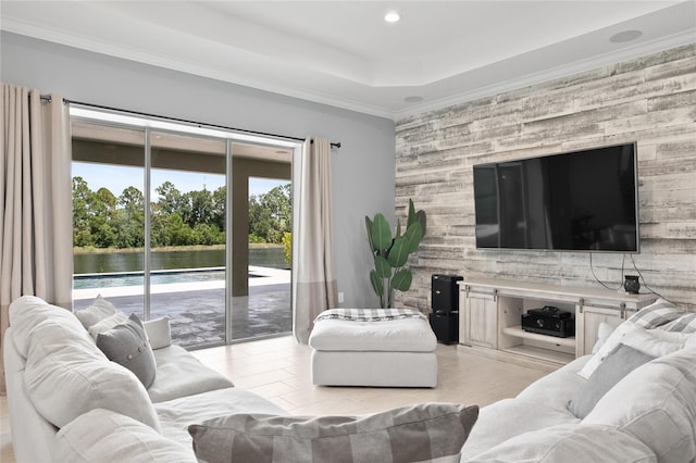 living room featuring a water view, a raised ceiling, crown molding, and recessed lighting