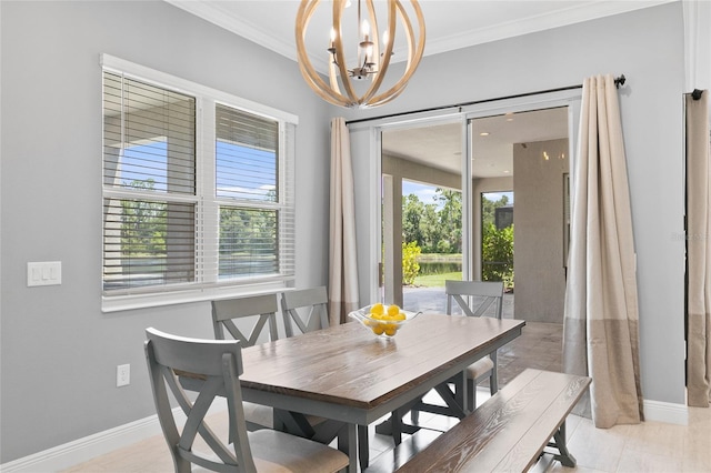 dining space with a chandelier, ornamental molding, and baseboards