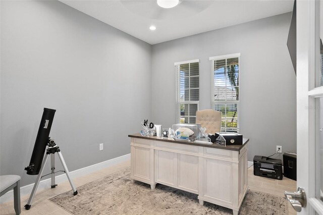 office featuring light tile patterned floors, ceiling fan, and baseboards