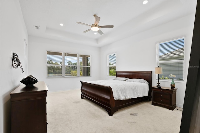 bedroom featuring light carpet, baseboards, a tray ceiling, and recessed lighting