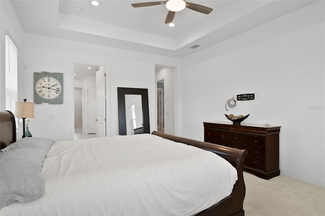 bedroom featuring recessed lighting, a raised ceiling, light colored carpet, and visible vents