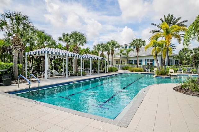 pool with a patio area and fence