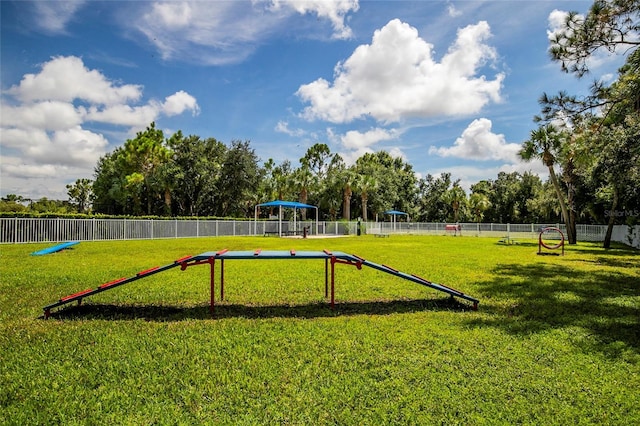 view of community with fence and a yard