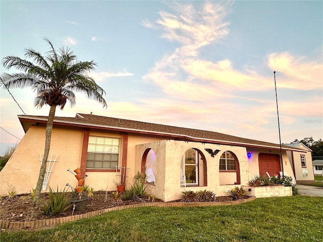 view of front of house with a lawn and stucco siding