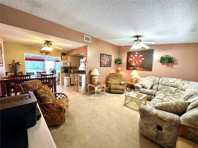 living room with light colored carpet, a textured ceiling, and ceiling fan