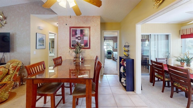 dining space with ceiling fan, light carpet, a textured ceiling, and vaulted ceiling