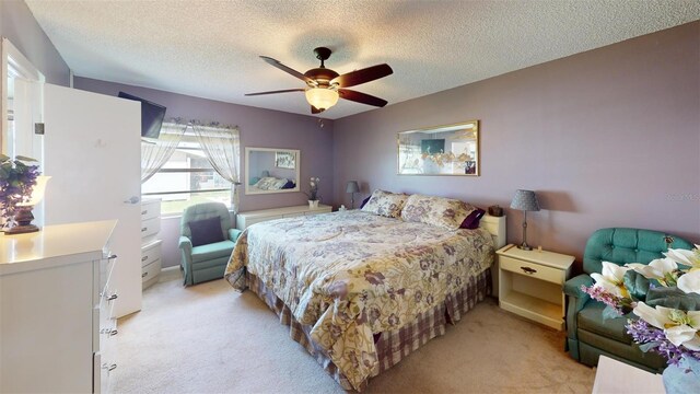 bedroom featuring light colored carpet, a textured ceiling, and ceiling fan