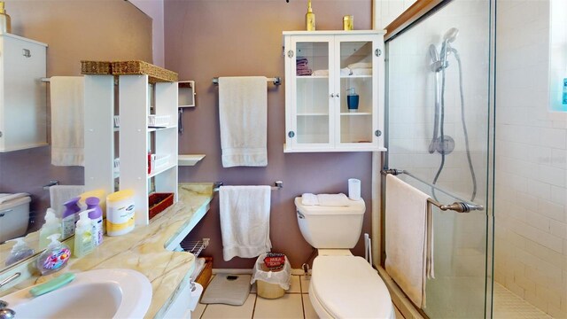 bathroom with tile patterned flooring, toilet, an enclosed shower, and vanity