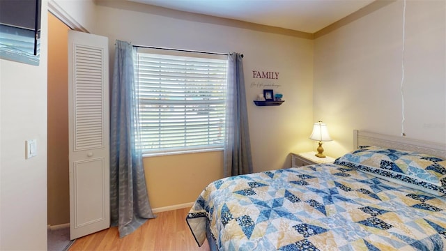 bedroom with baseboards and light wood finished floors