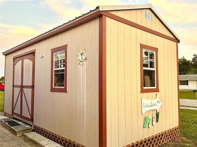 outdoor structure at dusk featuring a storage unit and an outdoor structure