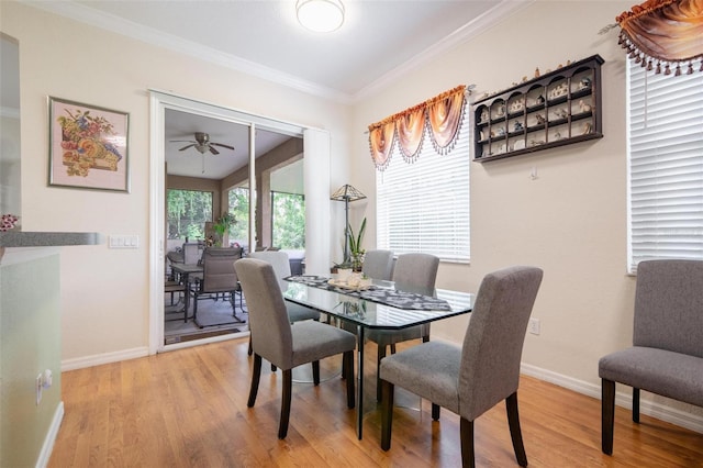 dining space with ceiling fan, light wood-type flooring, and ornamental molding