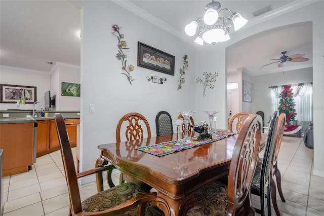 dining room featuring light tile patterned flooring, ceiling fan with notable chandelier, sink, and ornamental molding