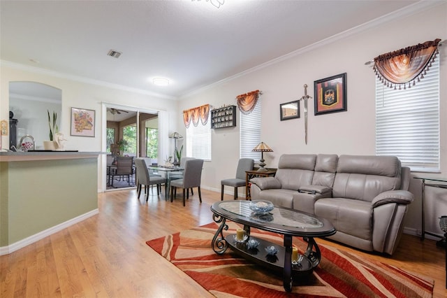 living room with light wood-type flooring and ornamental molding