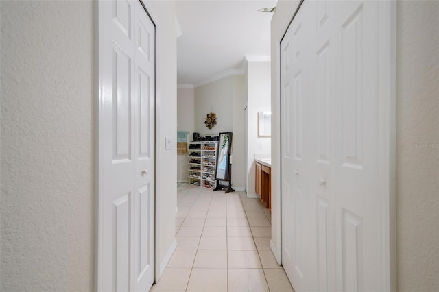 hallway featuring light tile patterned flooring and ornamental molding