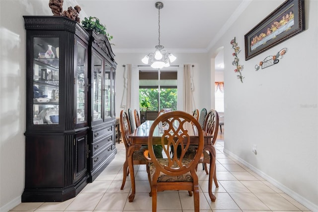 dining room featuring crown molding, a chandelier, and light tile patterned floors