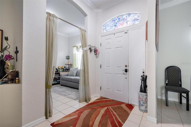 tiled foyer entrance featuring crown molding