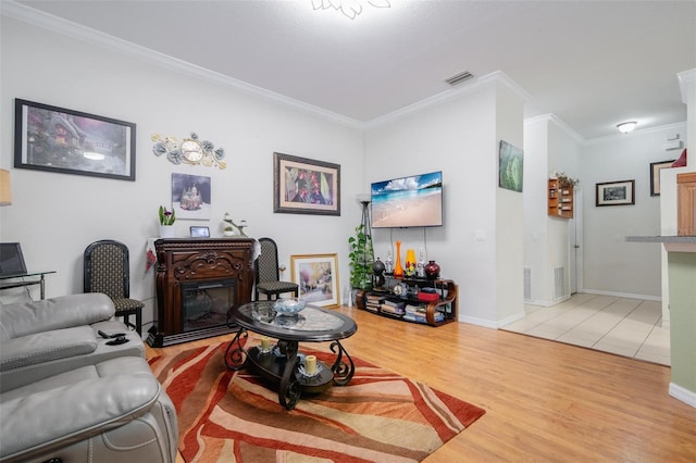 living room with light wood-type flooring and crown molding