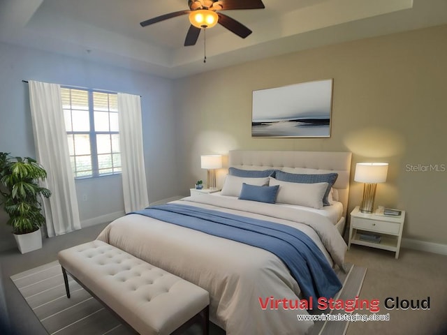 bedroom with ceiling fan and a raised ceiling