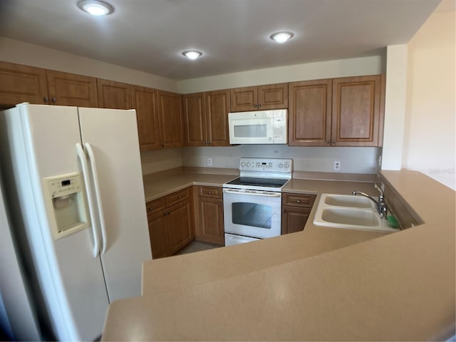 kitchen featuring sink, white appliances, and kitchen peninsula