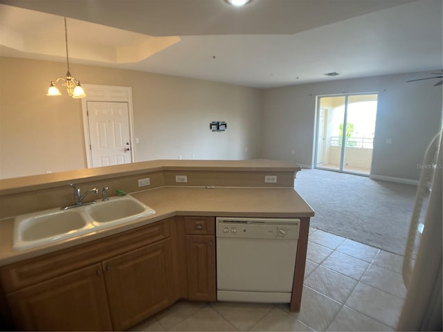 kitchen with sink, dishwasher, light tile patterned floors, a raised ceiling, and pendant lighting