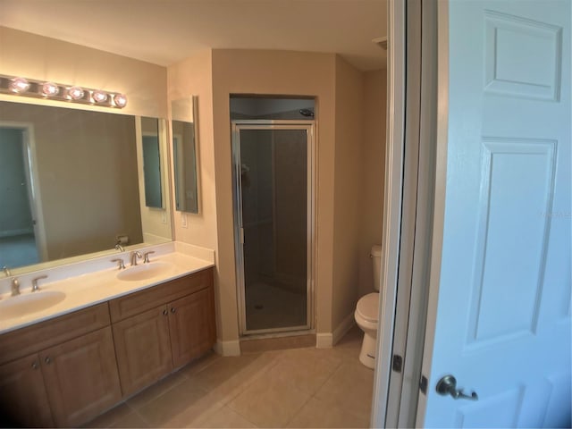 bathroom featuring an enclosed shower, toilet, dual vanity, and tile patterned floors