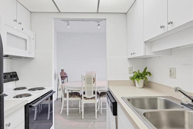 kitchen with white cabinets, white appliances, and sink