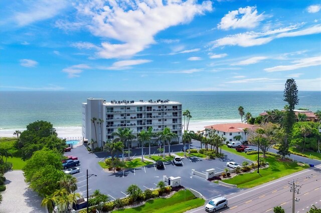 birds eye view of property with a water view and a beach view