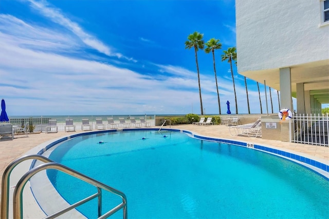 view of pool featuring a water view and a patio area