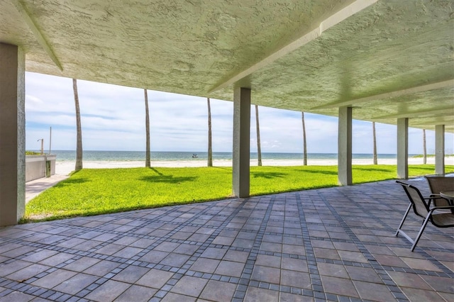 unfurnished sunroom with a water view and a view of the beach