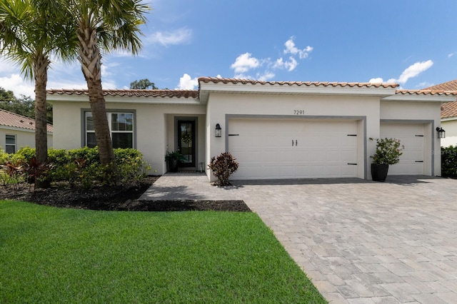 mediterranean / spanish-style home featuring a garage and a front lawn