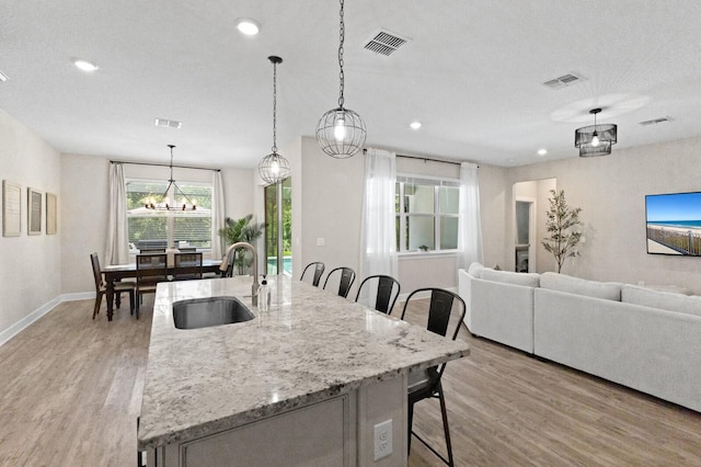 kitchen featuring sink, pendant lighting, and light wood-type flooring