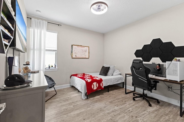 bedroom featuring a textured ceiling and light wood-type flooring