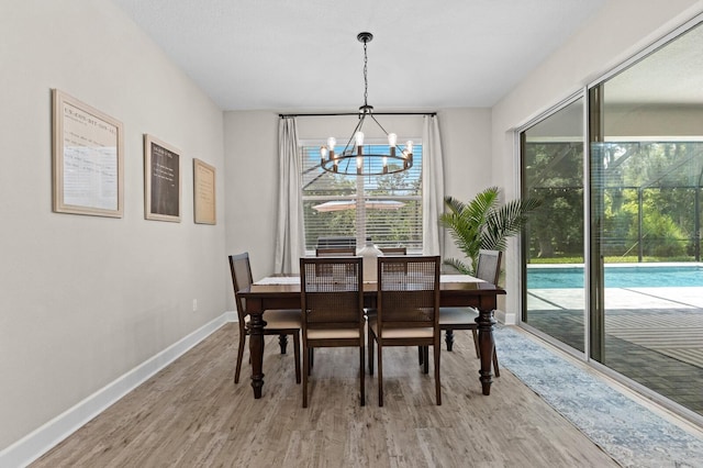 dining area with a notable chandelier and hardwood / wood-style flooring