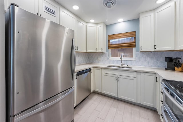 kitchen with white cabinetry, sink, appliances with stainless steel finishes, and tasteful backsplash