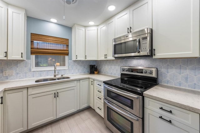 kitchen with white cabinets, light stone countertops, sink, and appliances with stainless steel finishes