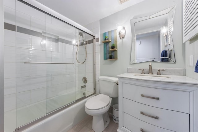 full bathroom featuring wood-type flooring, vanity, toilet, and enclosed tub / shower combo